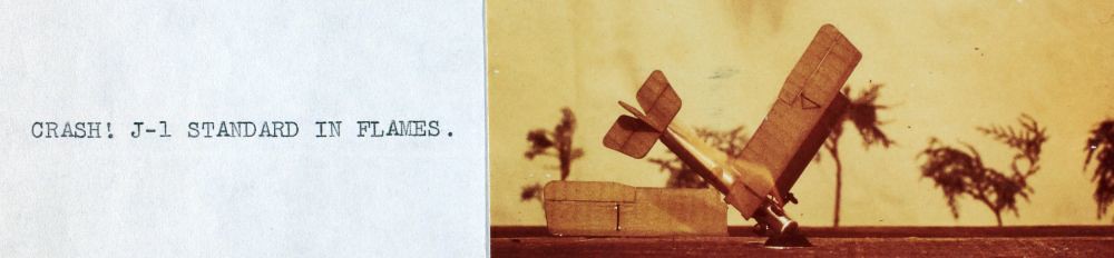 An antique photo of a biplane crashed in a field.